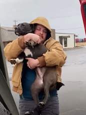 A man embraces a pit bull who was abandoned in a parking lot and decides to bring her home